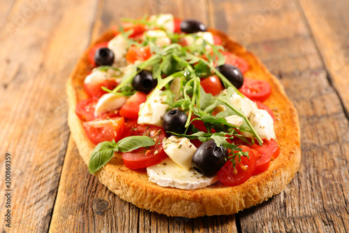 bruschetta with cheese, tomato, olive and rocket