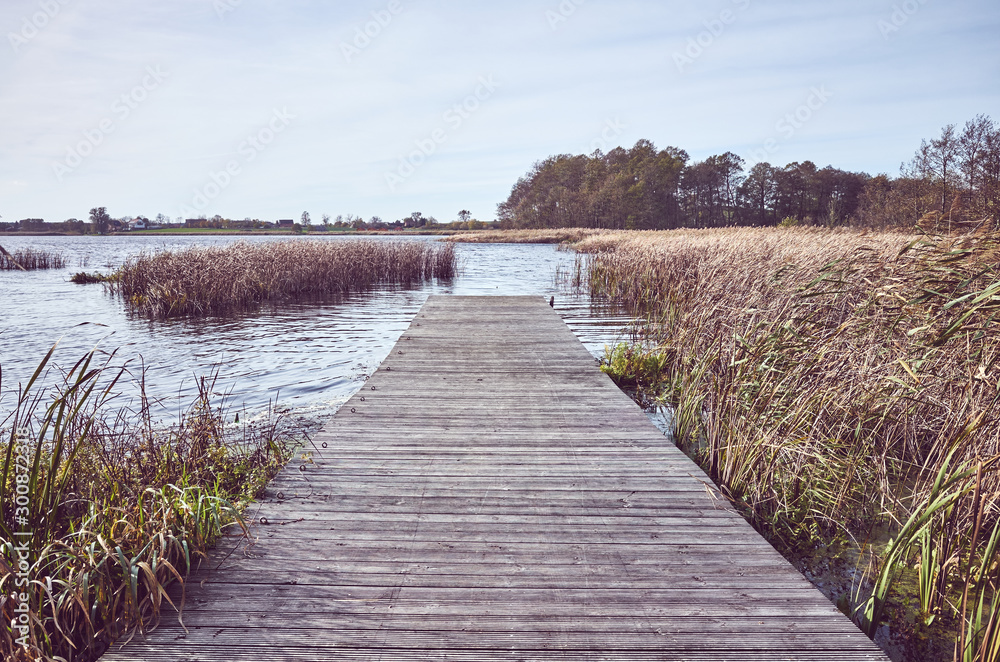 Obraz premium Retro toned picture of a wooden pier by lake in Autumn
