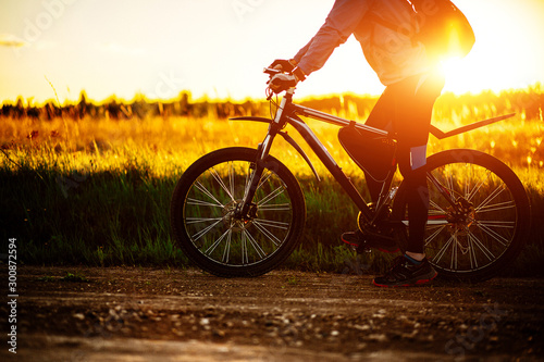 Man with a Bicycle in the field at sunset