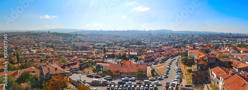 Panorama of the Old City of Ankara (Turkey) on an autumn sunny day. Top view of a parking with many cars, a mosque, residential buildings with red tiled roofs and skyscrapers on the horizon © ioanna_alexa