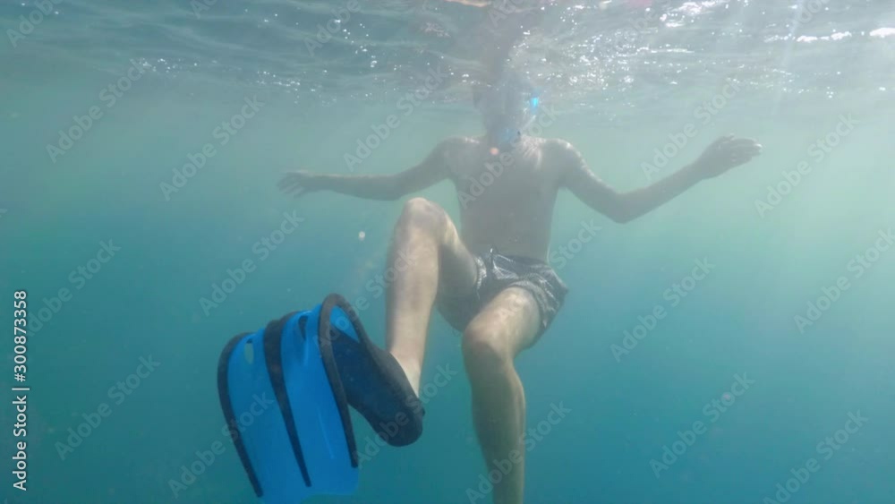 An underwater slow-motion clip of a boy swimming with fins in turquoise blue ocean in French Polynesia, Bora Bora. An underwater slow-motion clip of a boy swimming with fins in turquoise blue ocean in French Polynesia, Bora Bora.