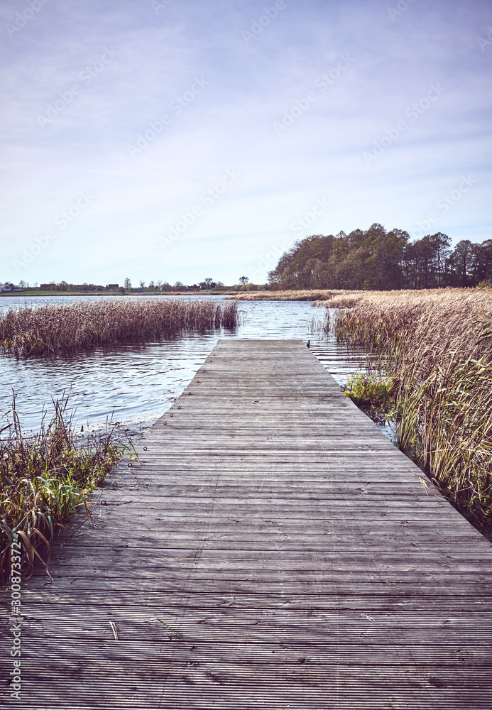 Fototapeta premium Retro toned picture of a wooden pier by lake in Autumn