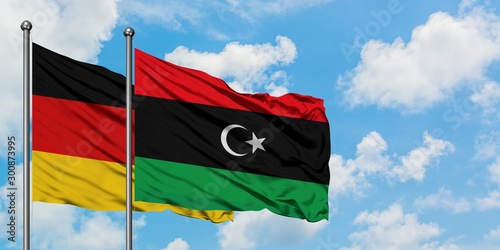 Germany and Libya flag waving in the wind against white cloudy blue sky together. Diplomacy concept, international relations.