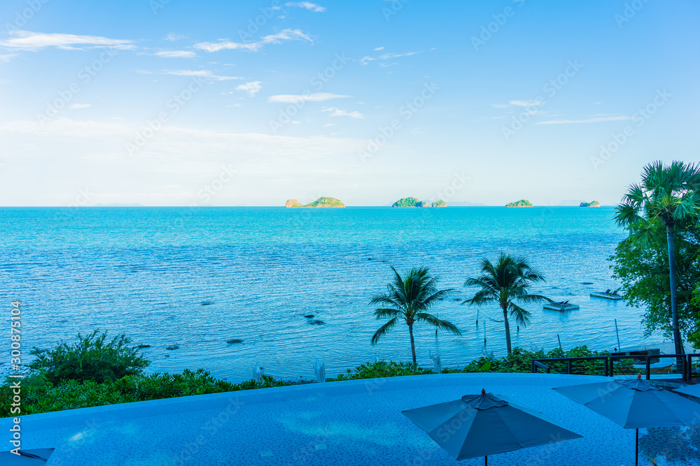 Fototapeta premium Umbrella and chair around beautiful luxury outdoor swimming pool with sea ocean view in hotel resort for holiday vacation travel