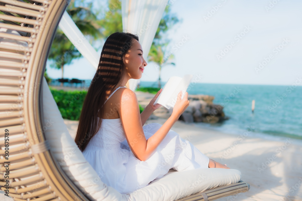 Portrait beautiful asian woman reading book around beach sea ocean