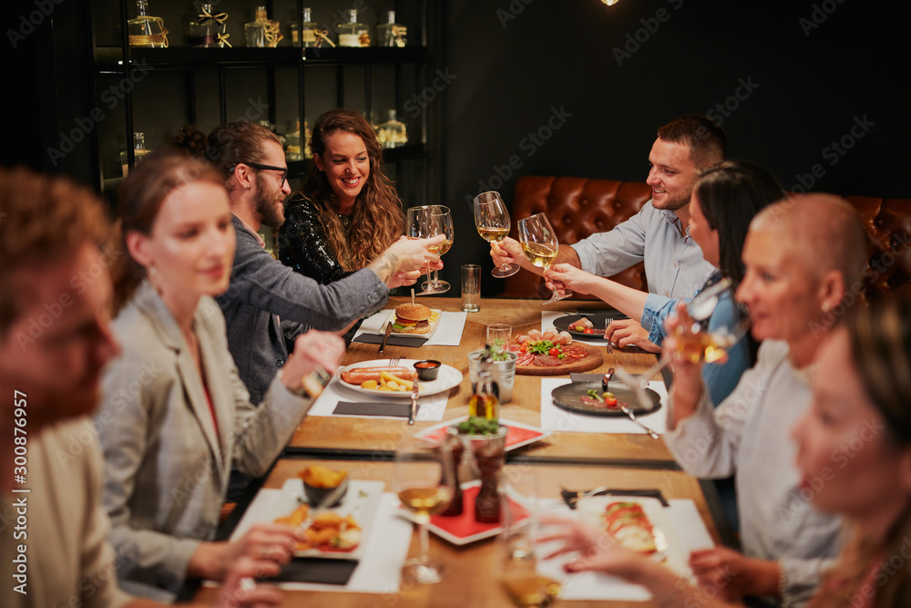 Group of best friends sitting in restaurant, having dinner, drinking wine and having fun. - obrazy, fototapety, plakaty 