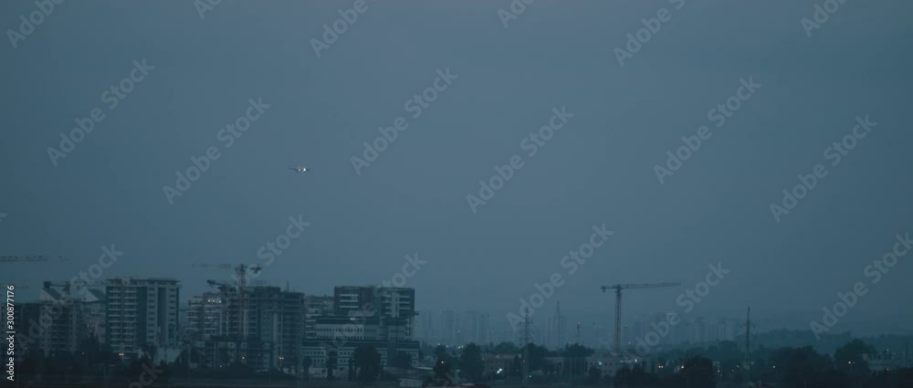 Plane coming in for landing at the airport with building construction in the background, slow motion BMPCC 4K Plane coming in for landing at the airport with building construction in the background, slow motion BMPCC 4K