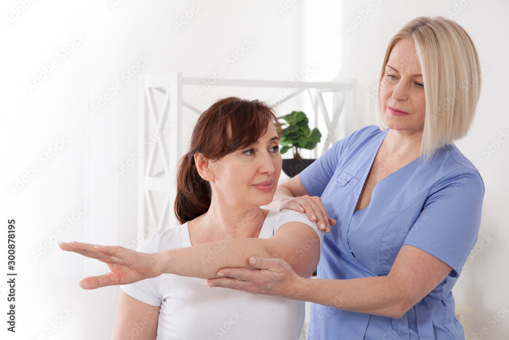 Physiotherapist working with middle aged patient in clinic