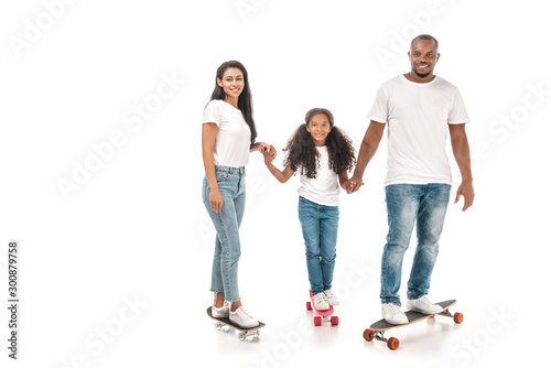 happy african american family standing on longboard, skate and penny board and holding hands on white background