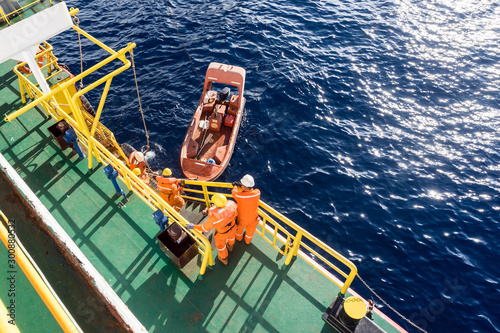 Fast rescue craft being deployed from a construction barge at oil field