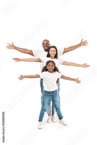 cheerful african american kid with parents imitating flying with outstretched hands on white background