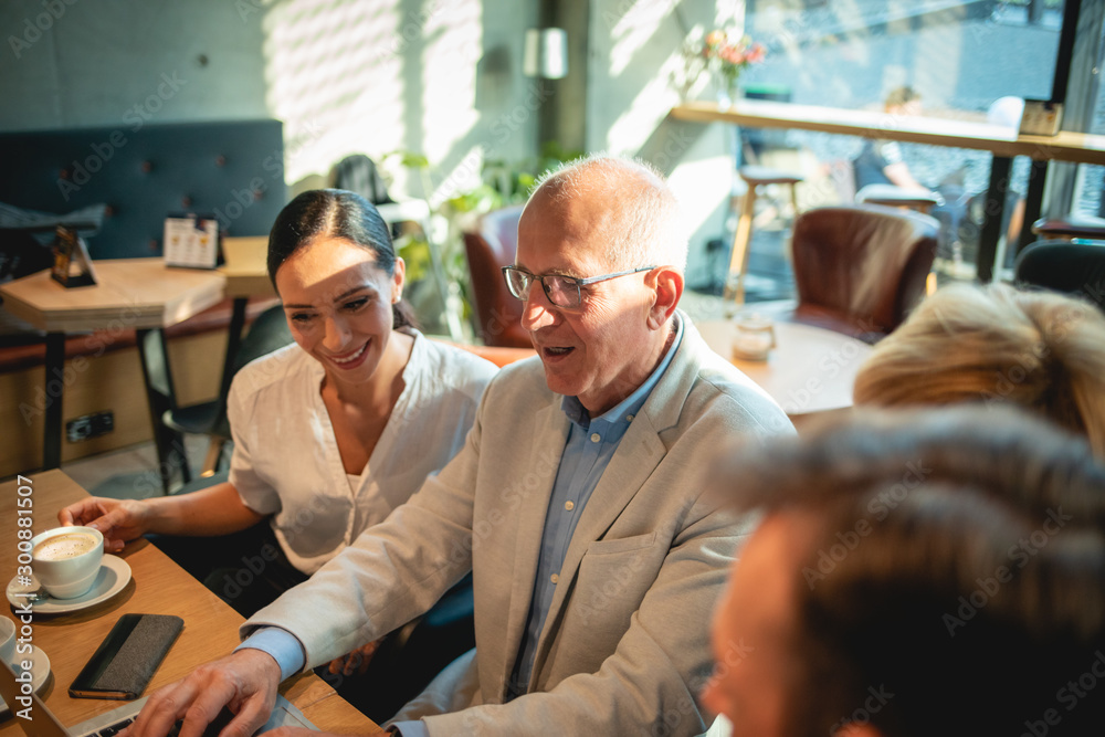 Business people looking at laptop at cafe and discussing Business people looking at laptop at cafe and discussing