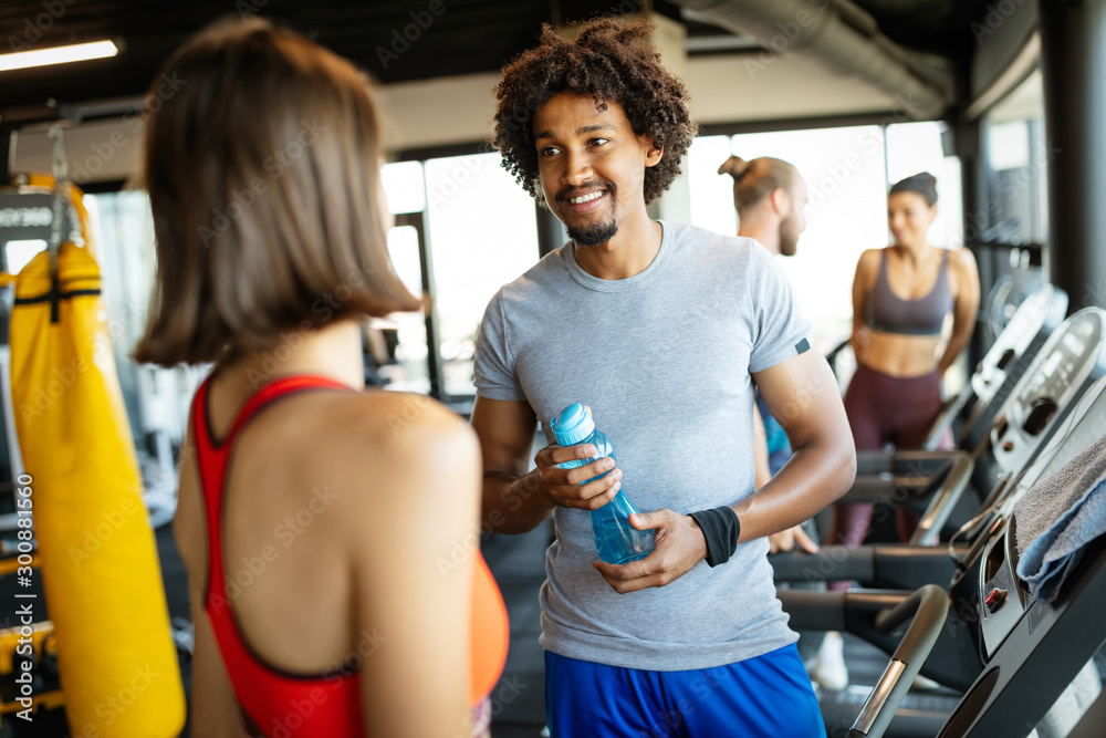 Happy friends enjoying break while chatting in the gym Happy friends enjoying break while chatting in the gym