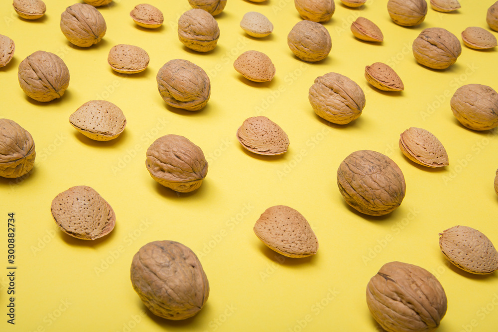 Still life with nuts and almonds on yellow background Still life with nuts and almonds on yellow background