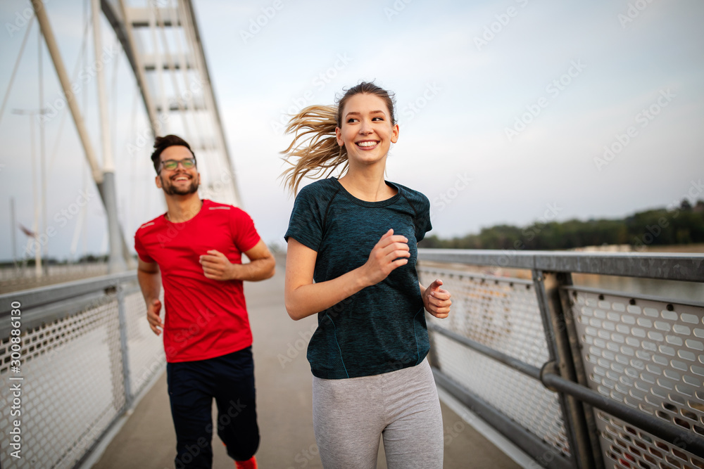Fitness, sport, people, exercising and lifestyle concept. Couple running outdoor - obrazy, fototapety, plakaty 