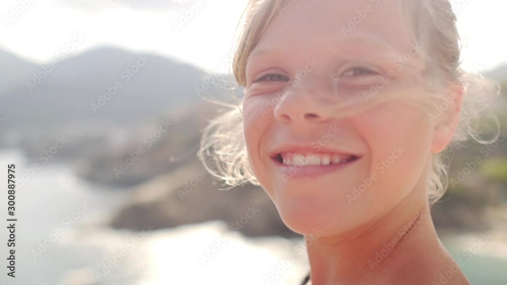 portrait of an authentic smiling young child with sunset background on the beach. portrait of an authentic smiling young child with sunset background on the beach.