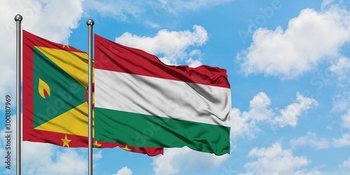 Grenada and Hungary flag waving in the wind against white cloudy blue sky together. Diplomacy concept  international relations.