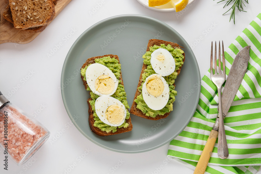 Avocado toast. Sandwich with egg, mashed on wholegrained bread. Healthy breakfast.