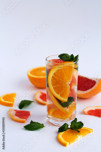healthy lifestyle. Fresh citrus fruit on white background. refreshing cocktail with slices of fresh orange and grapefruit with green mint leaves on white background. Detox citrus cocktail. copy space