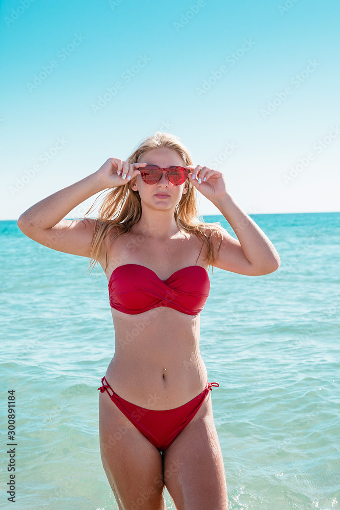 The girl in swimsuit went swimming on water. Beautiful blonde in red thong. The girl in swimsuit went swimming on water. Beautiful blonde in red thong.