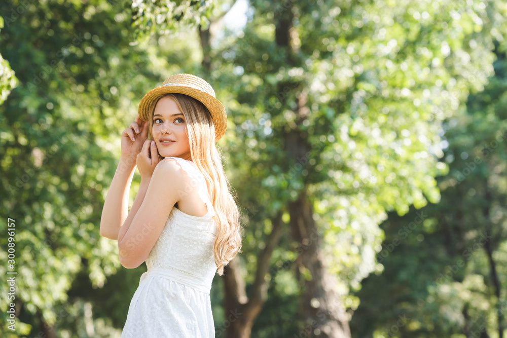 beautiful young girl in white dress and straw hat smiling and looking away beautiful young girl in white dress and straw hat smiling and looking away