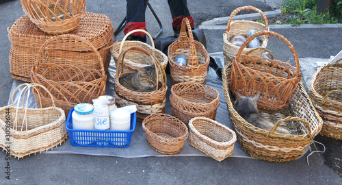 Wicker baskets are sold in the market and cats