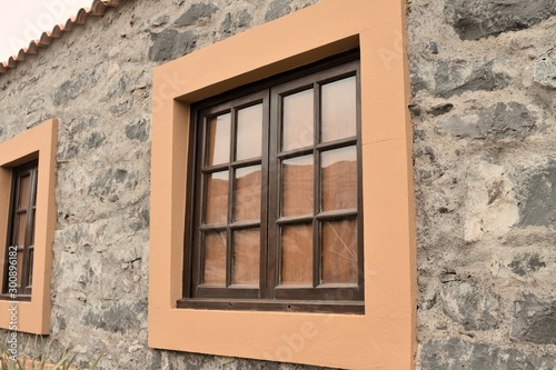 Exterior details of a stone building with orange framed windows (Madeira, Portugal, Europe)
