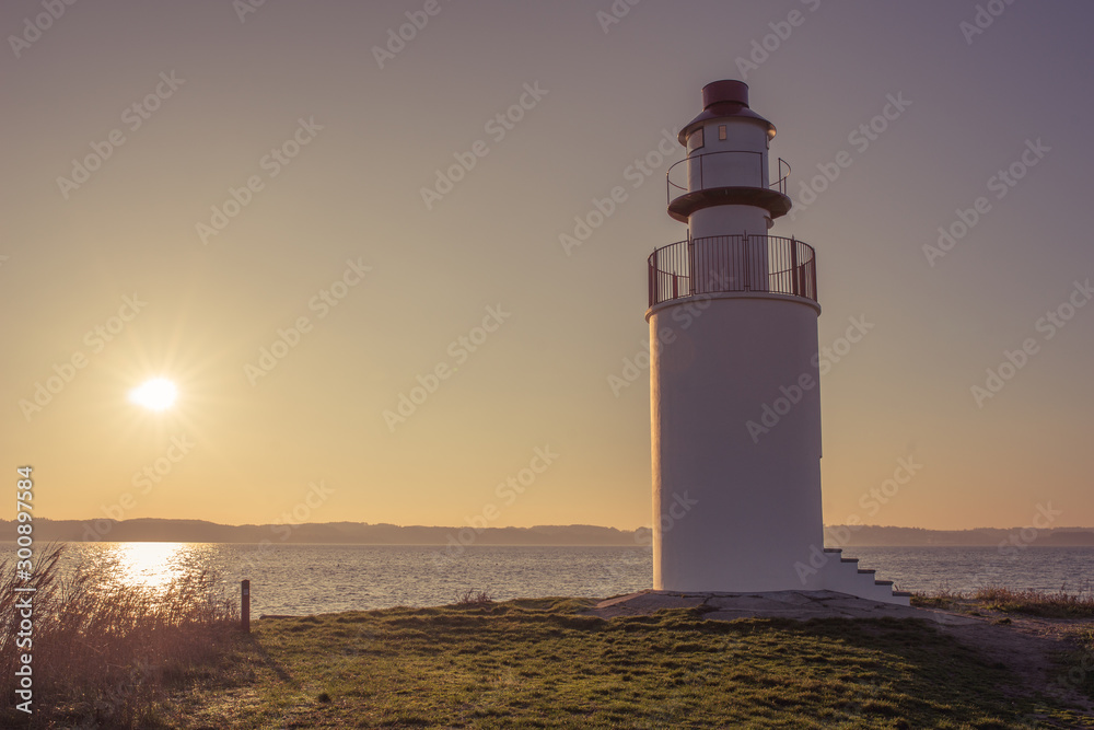 Lighthouse at sunset on Denmark's coastline.