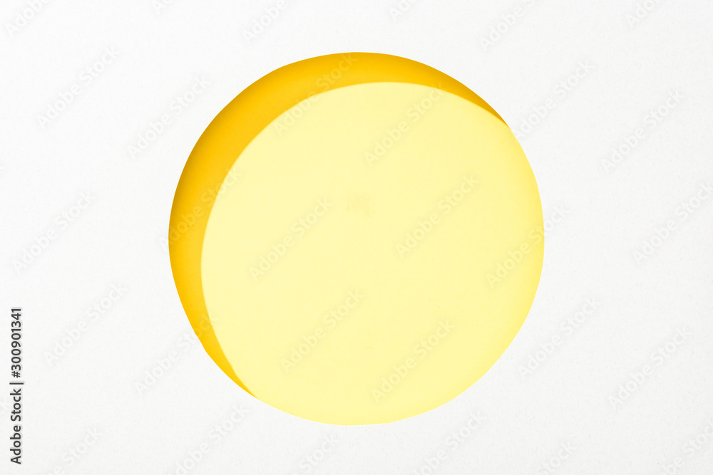cut out round hole in white paper on colorful yellow background