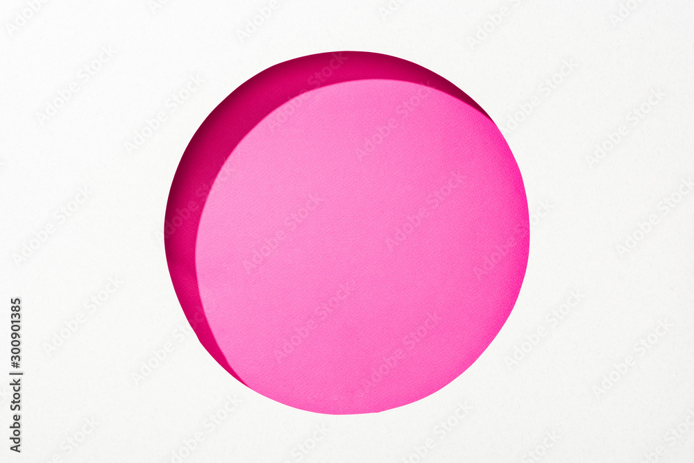 Obraz premium cut out round hole in white paper on pink colorful background
