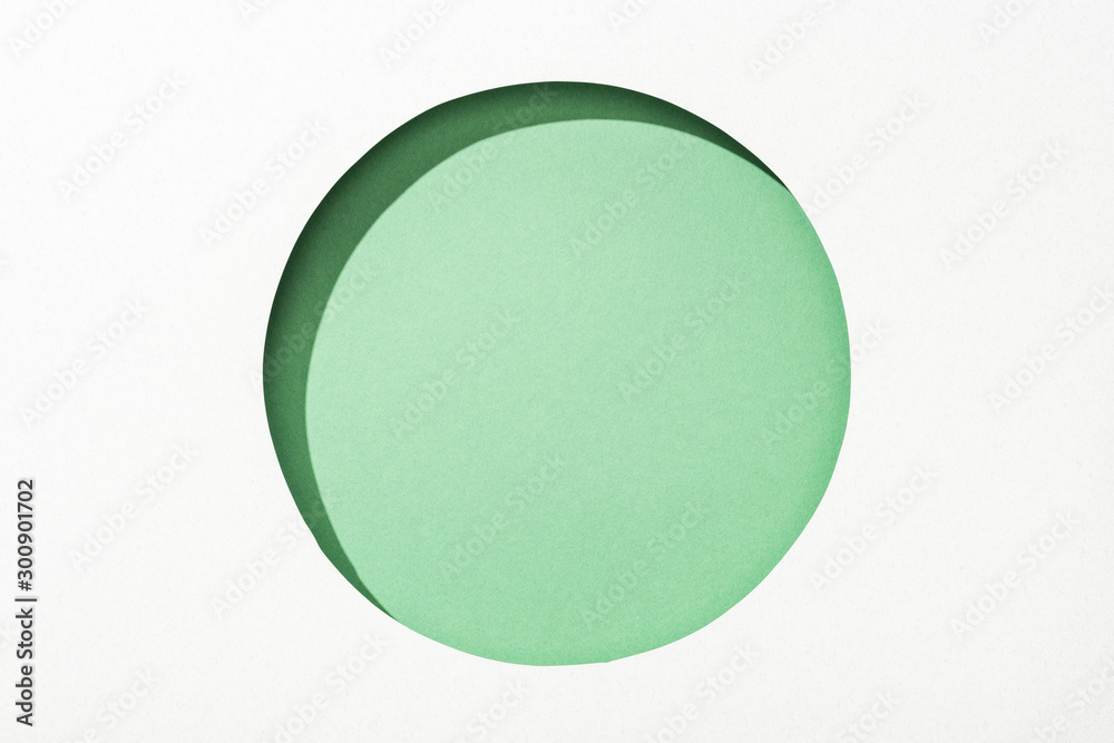 cut out round hole in white paper on green background