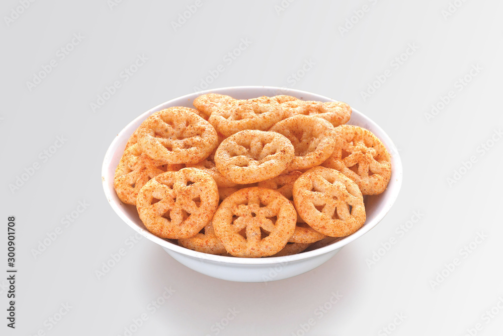 Fried and Spicy wheel Snacks or Fryums (Snacks Pellets) is a very popular Gujarati snack, white bowl on white background, pouch packing common street snack from India. selective focus - Image