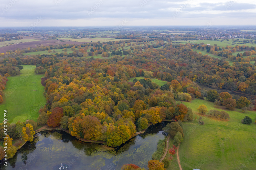 Aerial photo in autumn showing the beautiful autumn fall colours of a park in Leeds known as Roundhay Park in West Yorkshire UK, showing a typical British park and woods along side a lake.