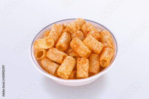 Fried and Spicy Tasty yellow pipe shaped fryums (Papad Pipe) very crispy. Children love them very much Snacks or Fryums (Snacks Pellets) served in a white bowl. selective focus - Image