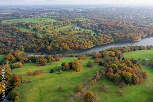 Aerial photo in autumn showing the beautiful autumn fall colours of a park in Leeds known as Roundhay Park in West Yorkshire UK, showing a typical British park and woods along side a lake. photo