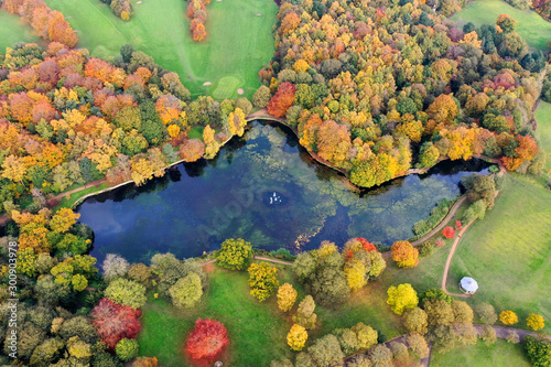 Obraz na plátně Aerial photo in autumn showing the beautiful autumn fall colours of a park in Leeds known as Roundhay Park in West Yorkshire UK, showing a typical British park and woods along side a lake