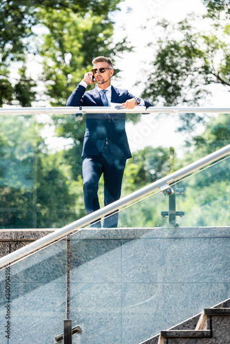 handsome businessman in suit and glasses talking on smartphone © LIGHTFIELD STUDIOS