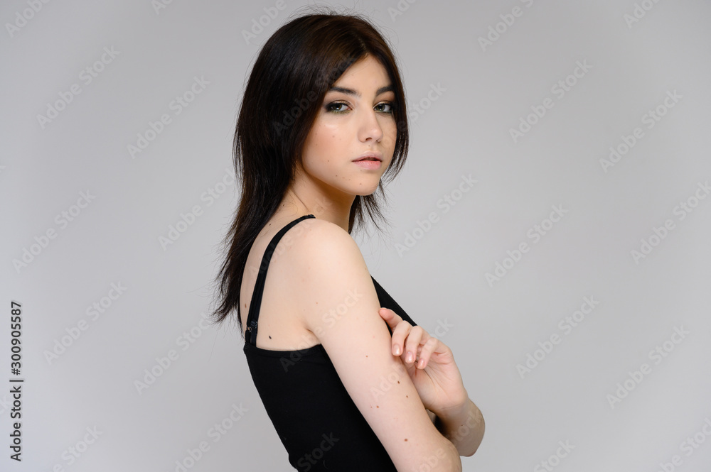 Close-up portrait of a young pretty girl student with long black hair, on a white background. He stands right in front of the camera, showing his hands in different poses with different emotions. Close-up portrait of a young pretty girl student with long black hair, on a white background. He stands right in front of the camera, showing his hands in different poses with different emotions.