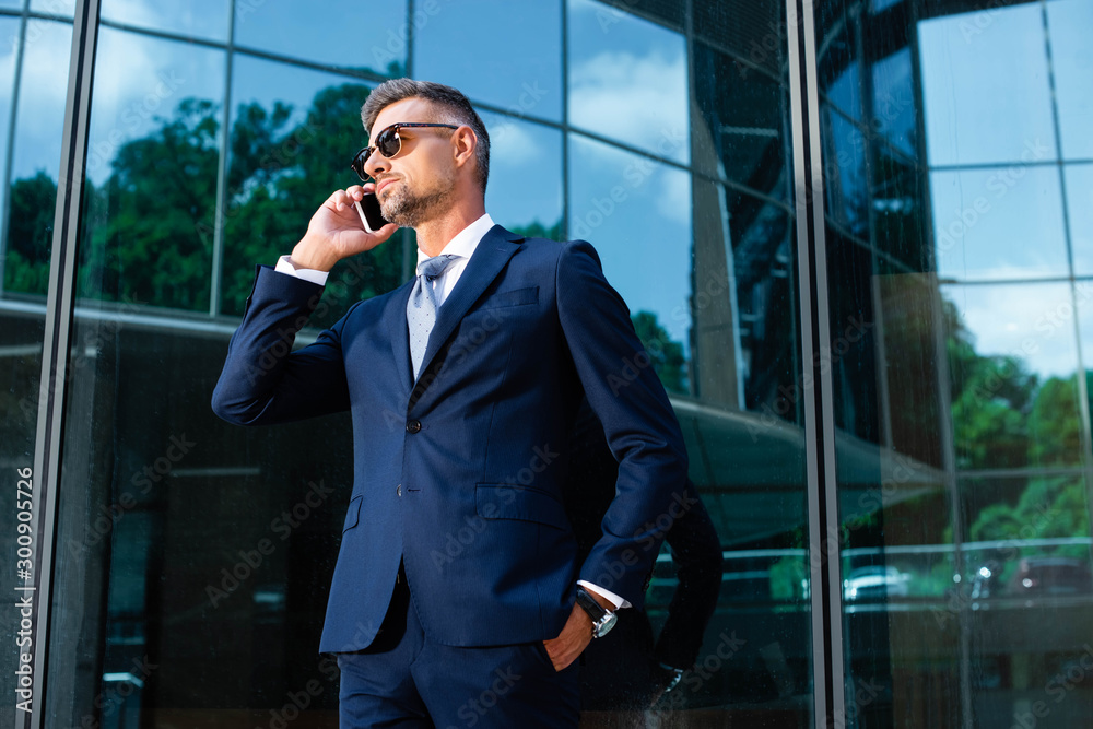 handsome man in suit and glasses talking on smartphone handsome man in suit and glasses talking on smartphone