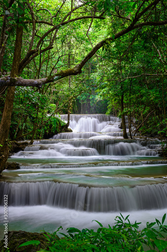 A beautiful waterfall deep in the tropical forest, steep mountain adventure in the rainforest. © Stock_ko