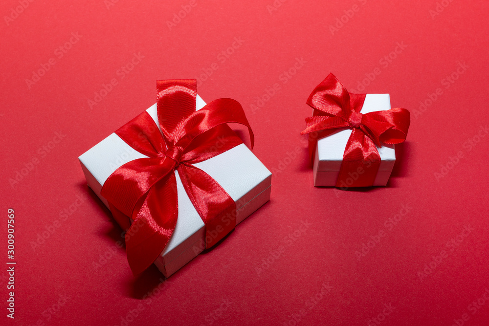 Two boxes with red ribbon and bow isolated on red. Boxing day . Two boxes with red ribbon and bow isolated on red. Boxing day .