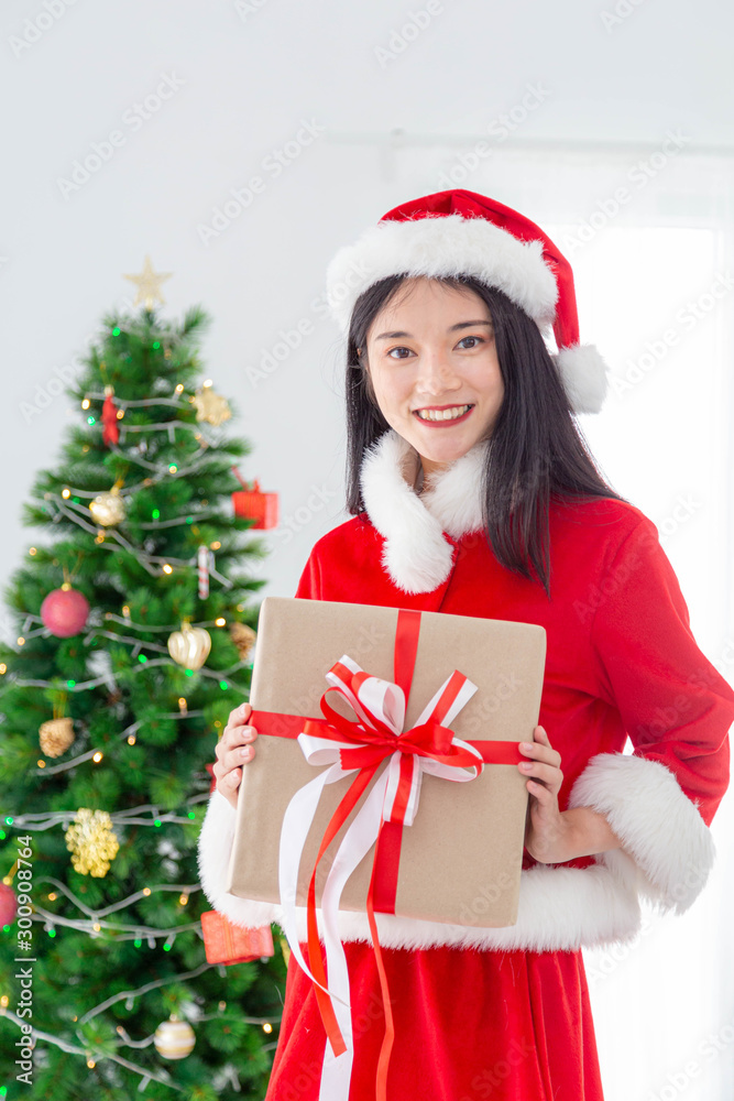 Merry Christmas and Happy Holiday-A beautiful woman wearing santa dress holding a special present box.