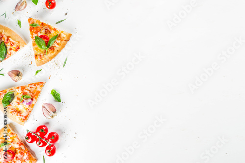 Pieces of cheese pizza Margarita with ingredients and herbs. White stone background top view