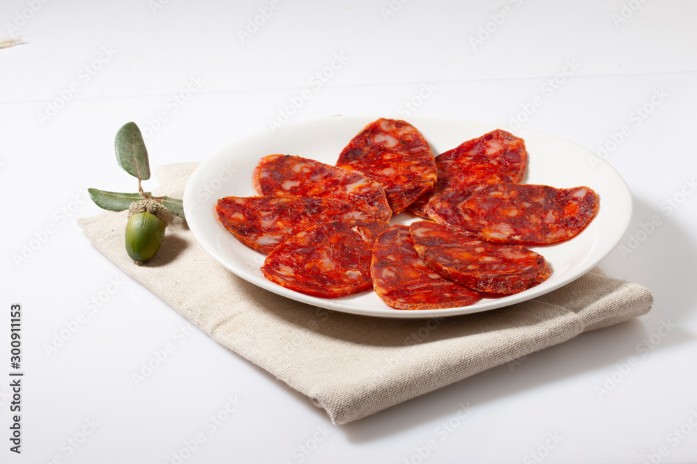 Chorizo  iberico cortado sobre fondo blanco. Iberian chorizo ​​sliced ​​on white background