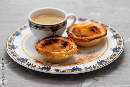 typical portuguese egg tart pastel de nata with cup of coffee on ceramic background