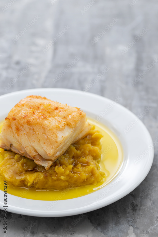 cod fish with sweet potato and olive oil on white dish