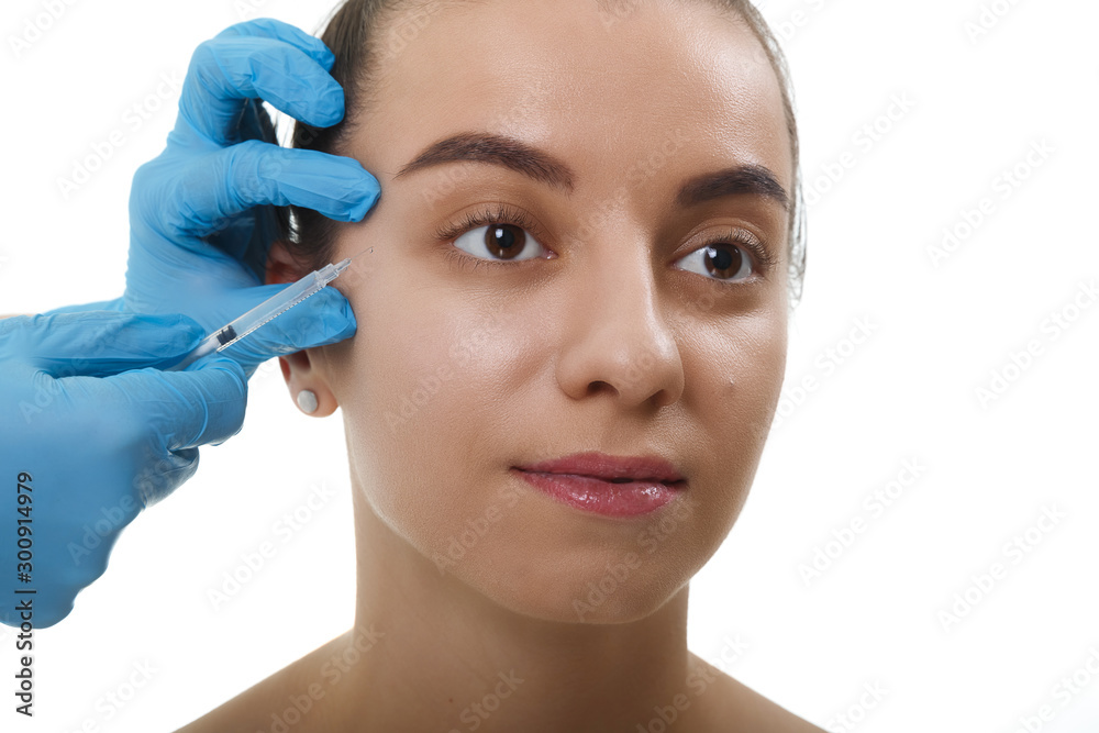 Closeup Beautician Hands Doing Facial Skin Lifting Injection To female. Beautiful young woman face and hand in glove with syringe making injection.