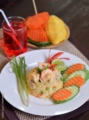 Fried rice with shrimp on the white dish on wooden table from top view