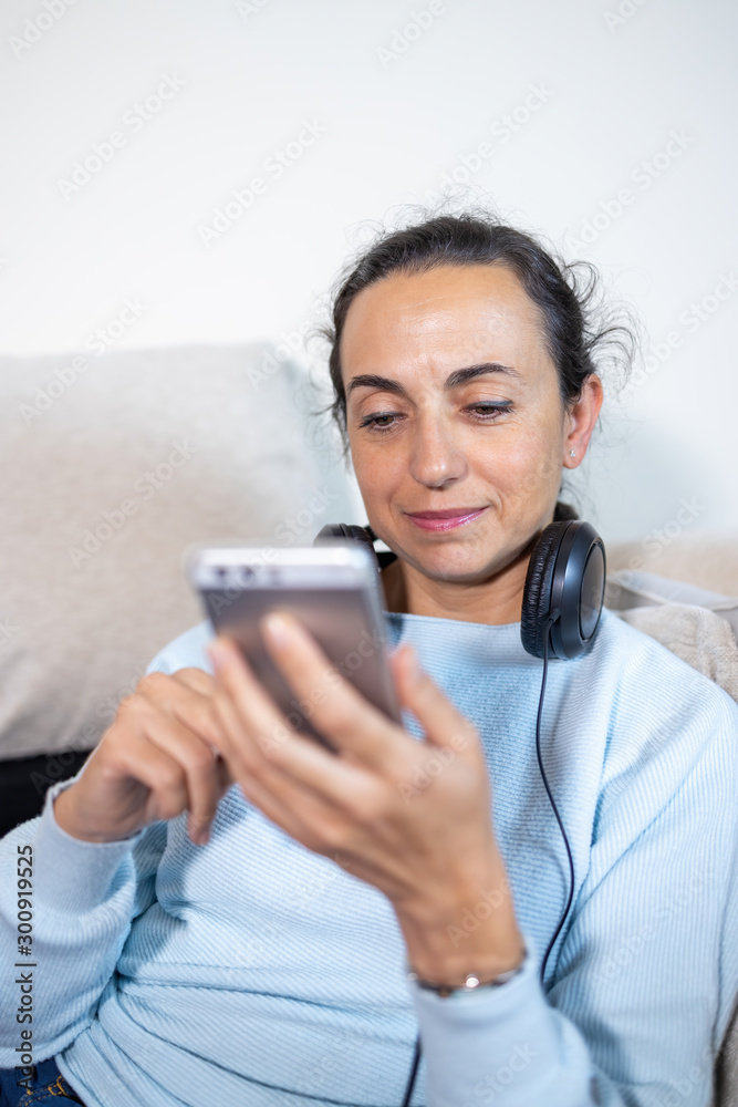 Pretty young spanish woman with smart phone at home Pretty young spanish woman with smart phone at home