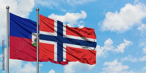 Obraz na płótnie Haiti and Bouvet Islands flag waving in the wind against white cloudy blue sky together
